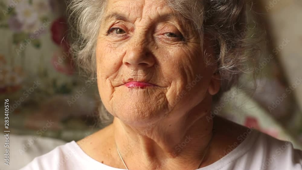 Elderly woman thoughtful wrinkled face with a white hairs and hand