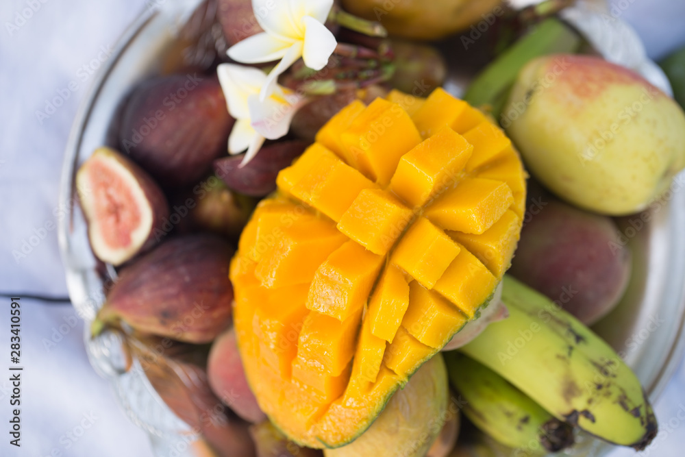 A plate of assorted fruits, sliced mango.