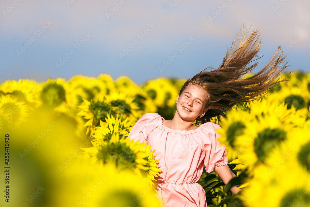 Beautiful girl bounced in a field of sunflowers rejoicing life Beautiful girl bounced in a field of sunflowers rejoicing life
