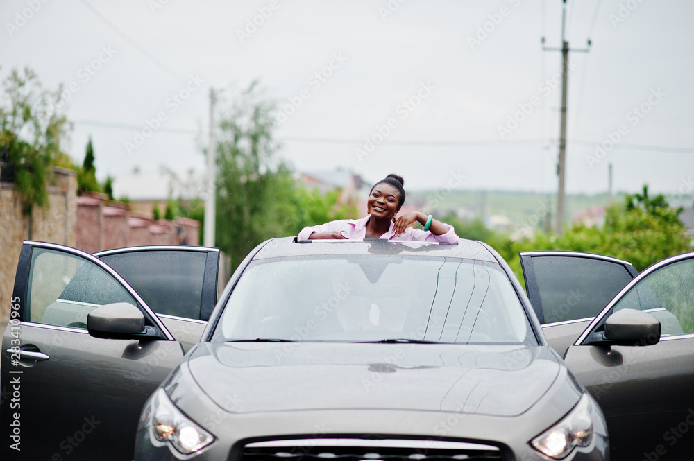 Rich business african woman in silver suv car on sunroof having fun. Rich business african woman in silver suv car on sunroof having fun.