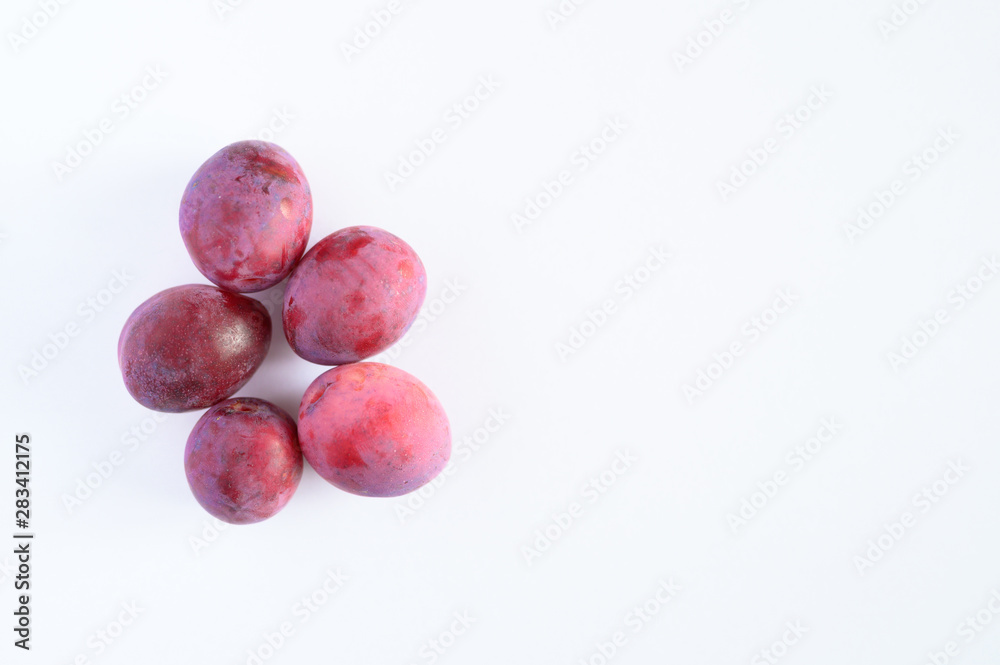 Several fresh ripe plums on white background