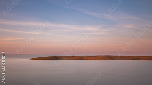 A long exposure of the clouds and water at Shingle Street in Suffolk. The water has taken on a milky effect and there is lots of negative space