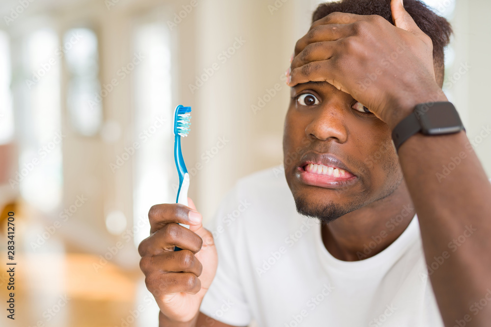 Foto Stock African american man holding toothbrush stressed with hand