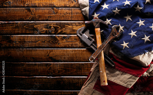 Old and worn work tools on large American flag - Labor day background photo