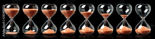 Φωτογραφία Collection of hourglasses with red sand showing the passage of time