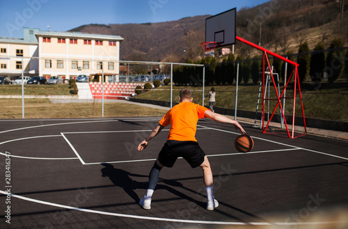 Active male basketball player on street court