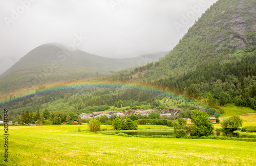 Colorful rainbow over the fields, lake and houses of Skei village, Jølster in Sogn og Fjordane county, Norway. photo