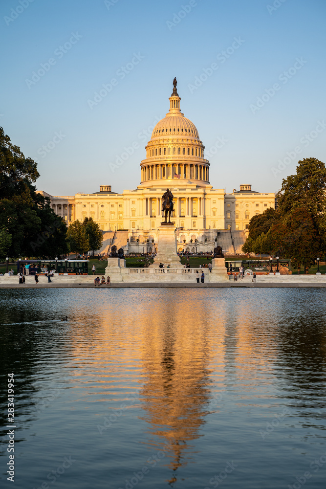 United States Capitol building at dusk sunset during a summer day, glowing from sunshine. Portrait orientation, with reflecting pond