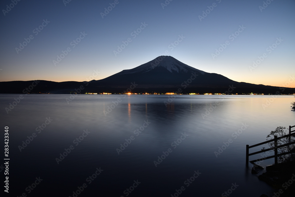 Mount Fuji reflected on lake in evening