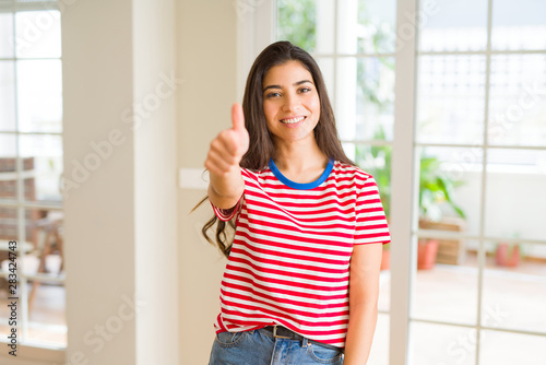 Beautiful young woman smiling excited doing thumbs up symbol, ok gesture © Krakenimages.com