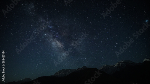 Milky way behind the mountains covered with snow