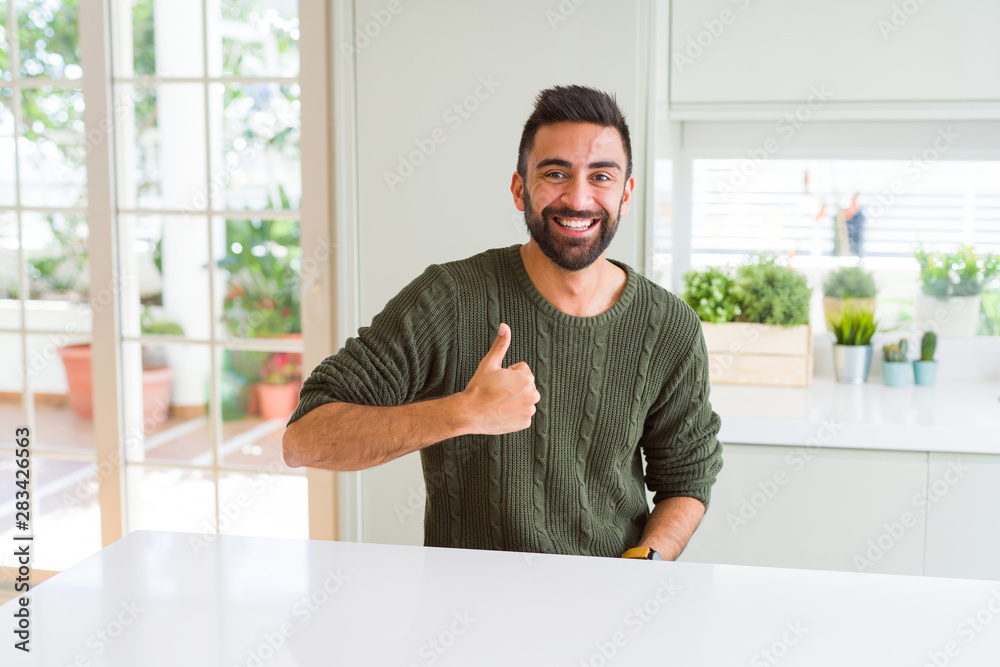 Handsome man smiling excited and doing ok sign with thumbs up, positive gesture and expression