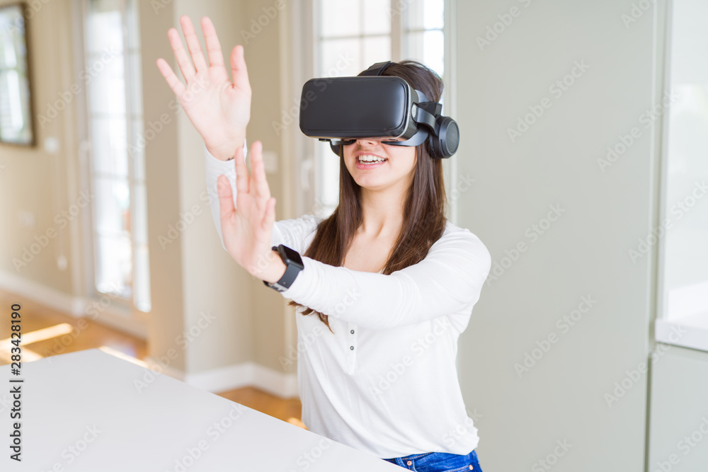 Young woman playing virtual reality game using simulation glasses headset, funny and amazing entertainment Young woman playing virtual reality game using simulation glasses headset, funny and amazing entertainment