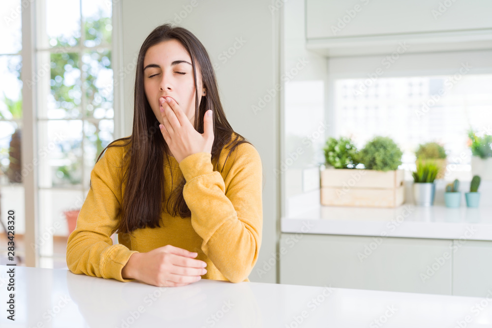 Beautiful young woman wearing yellow sweater bored yawning tired covering mouth with hand. Restless and sleepiness. Beautiful young woman wearing yellow sweater bored yawning tired covering mouth with hand. Restless and sleepiness.