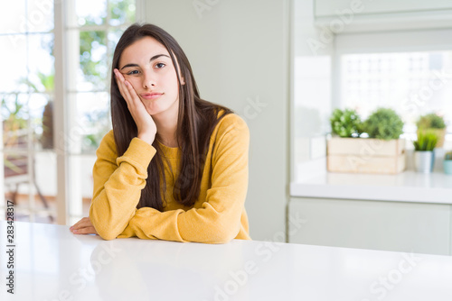Fotografie Beautiful young woman wearing yellow sweater thinking looking tired and bored with depression problems with crossed arms