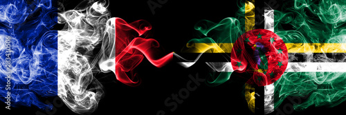 France vs Dominica smoky mystic flags placed side by side. Thick colored silky abstract smoke banner of French and Dominica photo