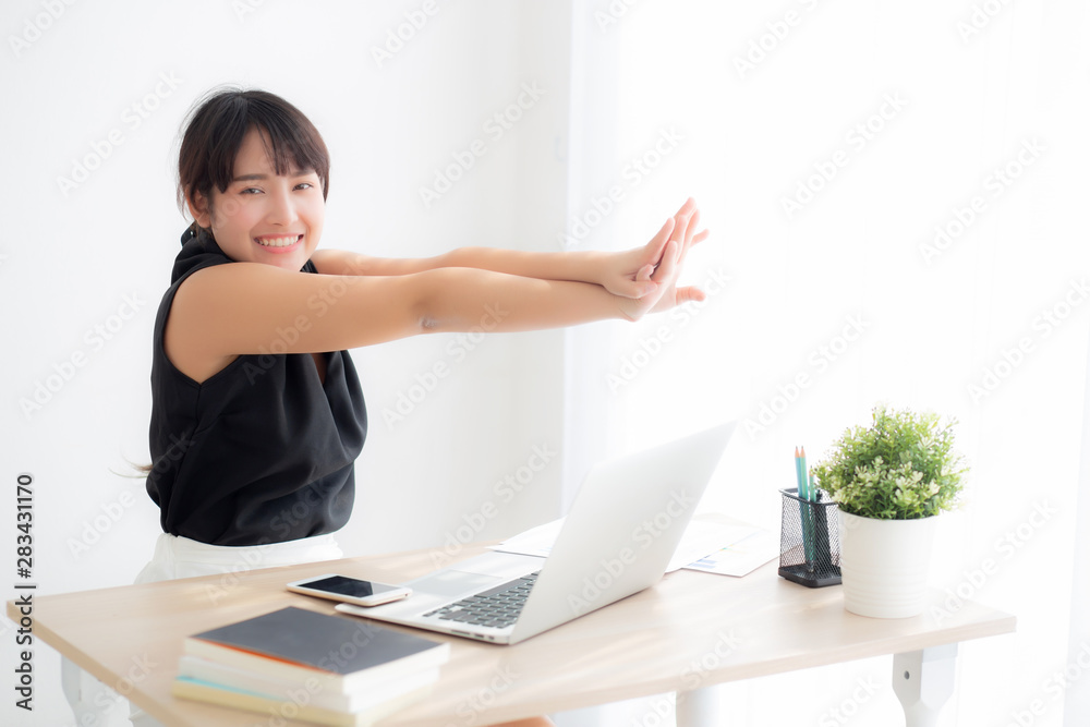 Obraz premium Beautiful portrait asian woman stretching muscle arms after working with laptop for protect office syndrome with relax, asia girl leisure and exercise because tired, business and healthy concept.