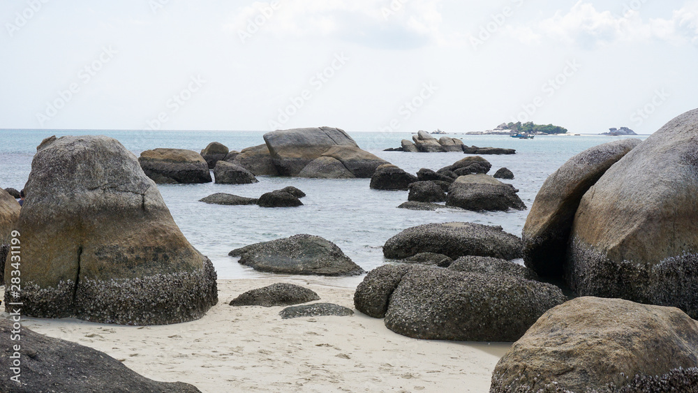 Giant rocks with small shells on the beach