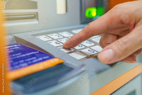 Hand entering on pin pad of ATM pass code