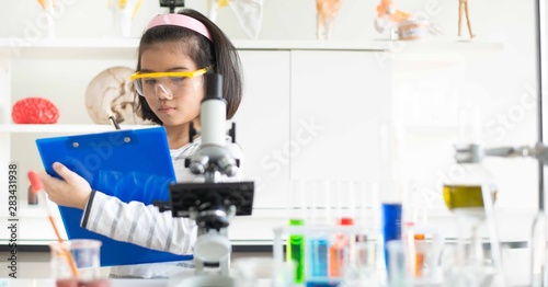Kid learning science in chemical laboratory.