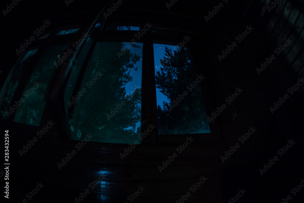 Night scene of stars seen through the window from dark room. Night sky inside dark room. Night scene of stars seen through the window from dark room. Night sky inside dark room.