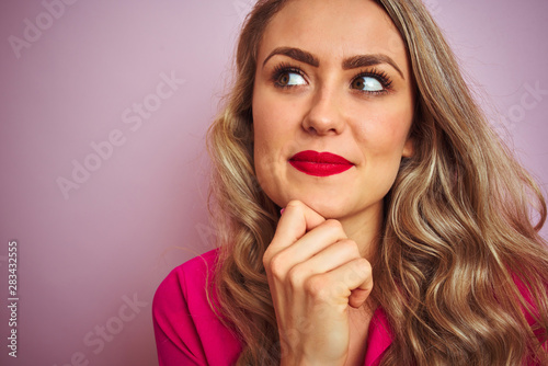 Young beautiful woman wearing elegant shirt standing over pink isolated background serious face thinking about question, very confused idea