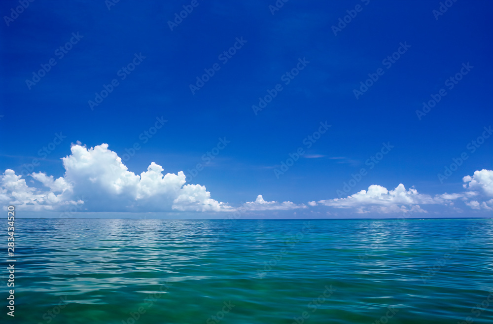 Obraz premium Line of clouds over mainland of Belize, Central America; view from kayak in Caribbean Sea.
