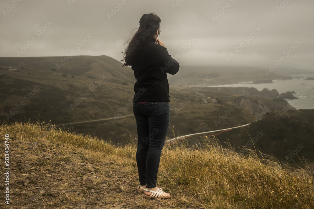 young woman overlooking coast of california young woman overlooking coast of california