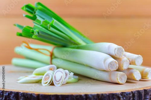 Fresh lemongrass rope and lemongrass slice on wooden cutting board in cooking concept. photo