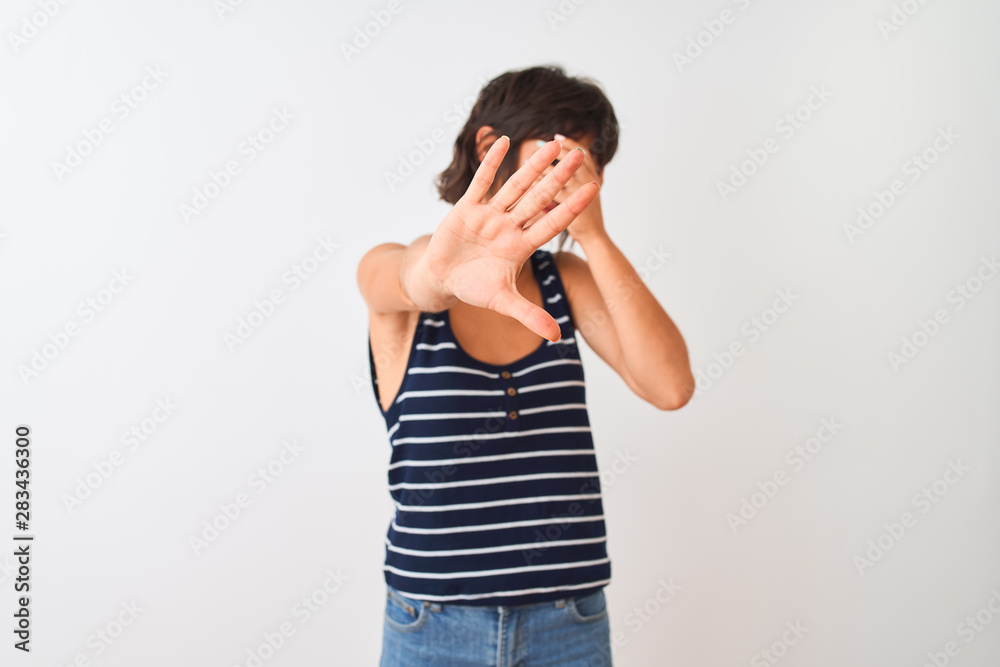 Young beautiful woman wearing striped t-shirt standing over isolated white background covering eyes with hands and doing stop gesture with sad and fear expression. Embarrassed and negative concept. Young beautiful woman wearing striped t-shirt standing over isolated white background covering eyes with hands and doing stop gesture with sad and fear expression. Embarrassed and negative concept.