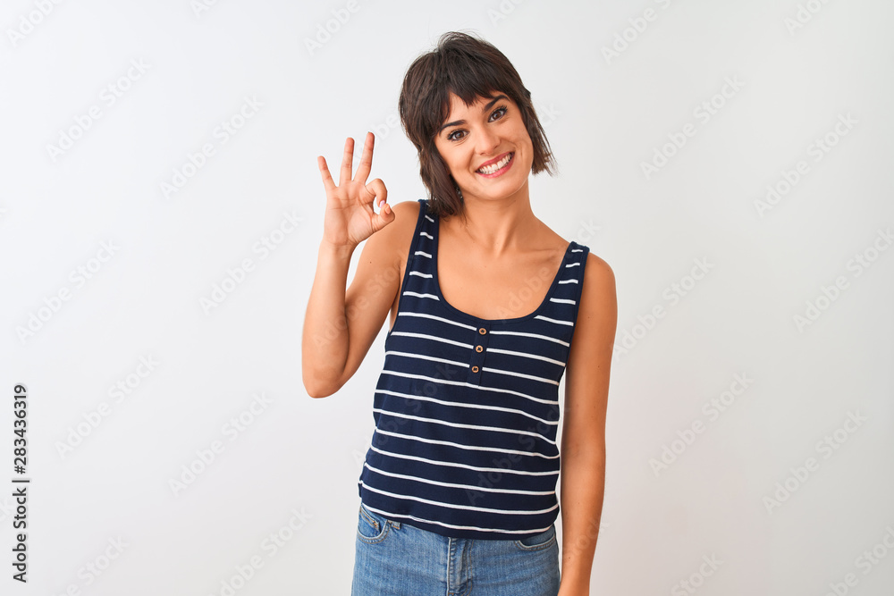 Young beautiful woman wearing striped t-shirt standing over isolated white background smiling positive doing ok sign with hand and fingers. Successful expression. Young beautiful woman wearing striped t-shirt standing over isolated white background smiling positive doing ok sign with hand and fingers. Successful expression.