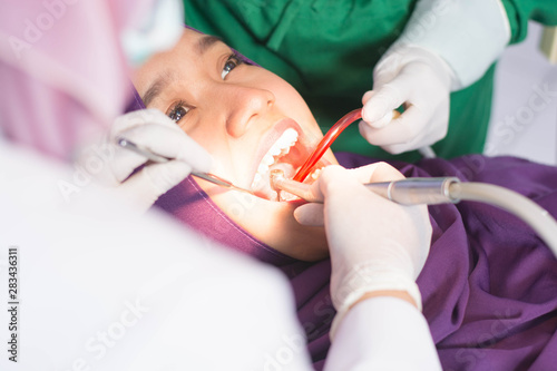 close up Portrait of hijab woman have examining in dentist chair