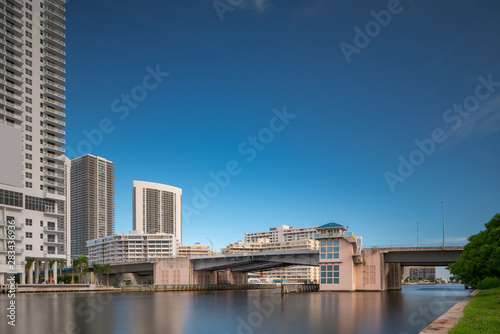 Hallandale Beach FL draw bridge over intracoastal waterway with blue sky. 30 second exposure for smooth silky water surface