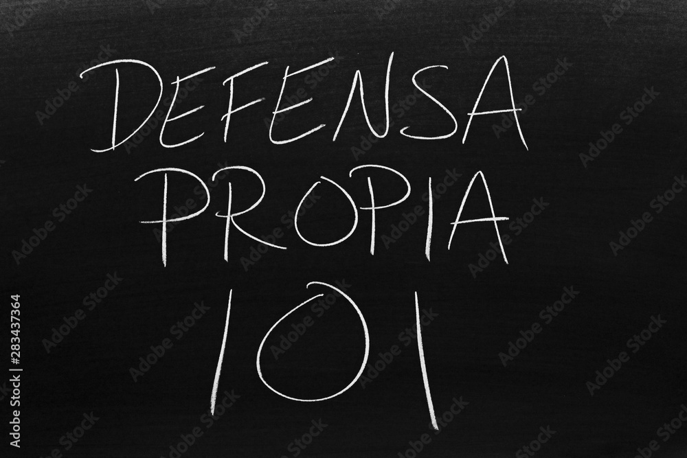 The words Defensa Propia 101 on a blackboard in chalk. Translation: Self Defense 101 The words Defensa Propia 101 on a blackboard in chalk. Translation: Self Defense 101