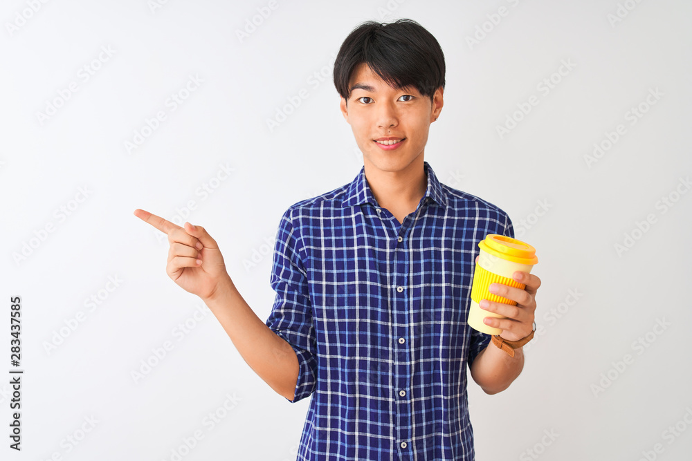 Young chinese man drinking take away coffee standing over isolated white background very happy pointing with hand and finger to the side Young chinese man drinking take away coffee standing over isolated white background very happy pointing with hand and finger to the side