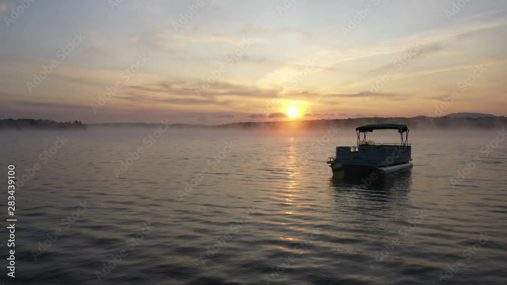 Wide aerial shot pushing toward abandoned boat under sunrise. Wide aerial shot pushing toward abandoned boat under sunrise.