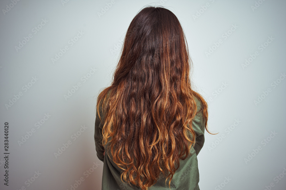 Young beautiful woman wearing green shirt standing over grey isolated background standing backwards looking away with crossed arms Young beautiful woman wearing green shirt standing over grey isolated background standing backwards looking away with crossed arms