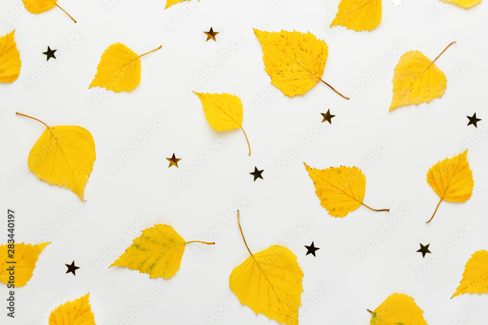 Autumn creative composition. Yellow leaves and golden stars on white background. Fall concept.  Flat lay, top view.