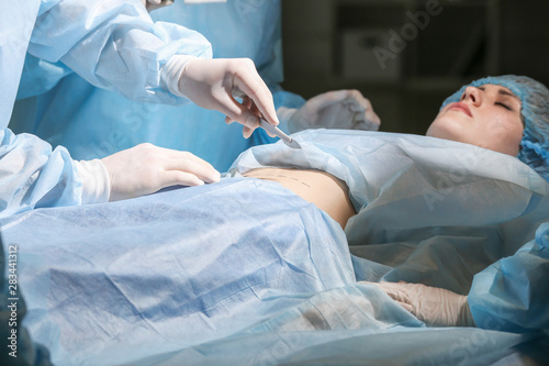 Plastic surgeons operating patient in clinic