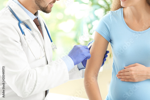 Doctor vaccinating pregnant...