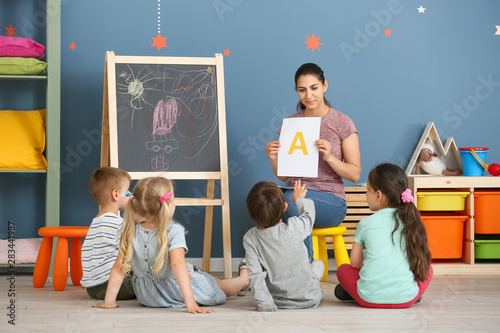 Obraz na plátně Cute little children learning letters in kindergarten