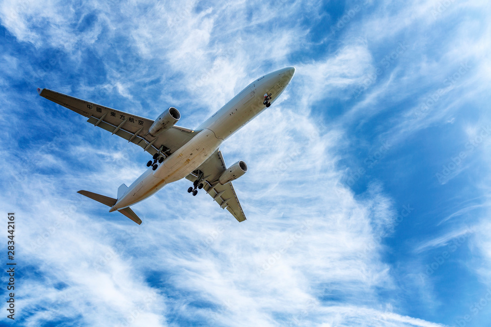 Passenger plane in a bright cloudy blue sky, Close-up.