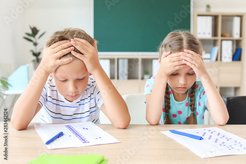 Φωτογραφία Pupils passing difficult school test in classroom