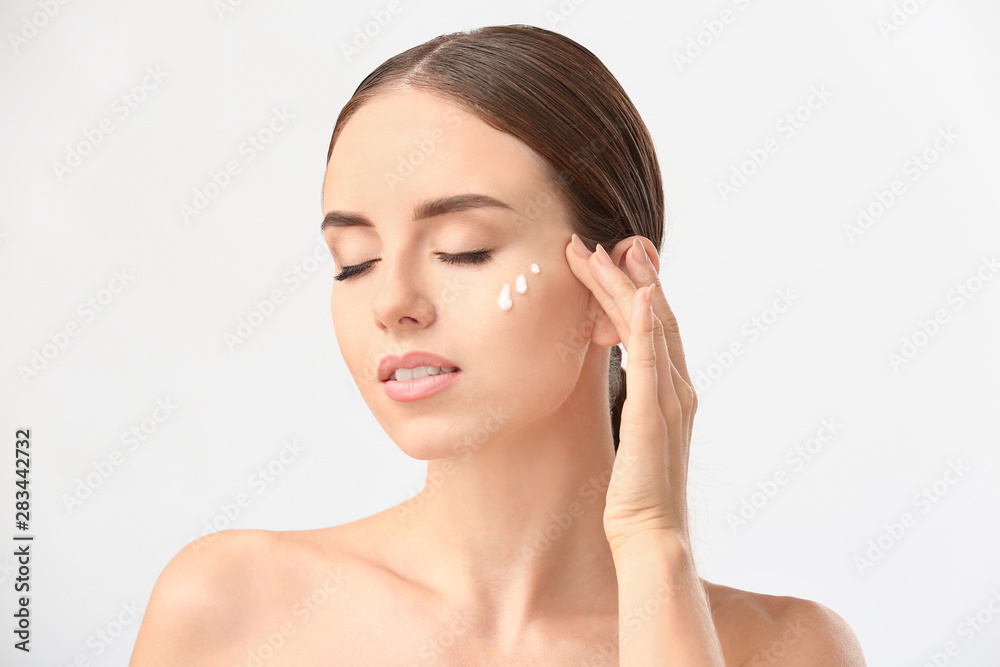 Woman with cosmetics on her face against white background Woman with cosmetics on her face against white background