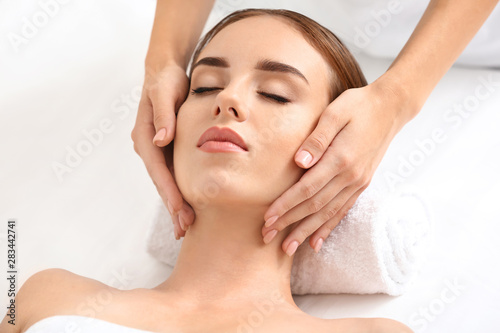 Young woman having facial massage in beauty salon