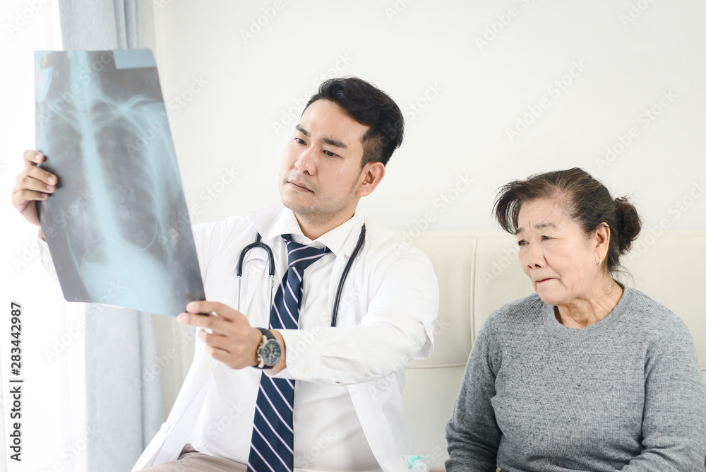 Doctor showing x-ray results to elderly woman Doctor showing x-ray results to elderly woman