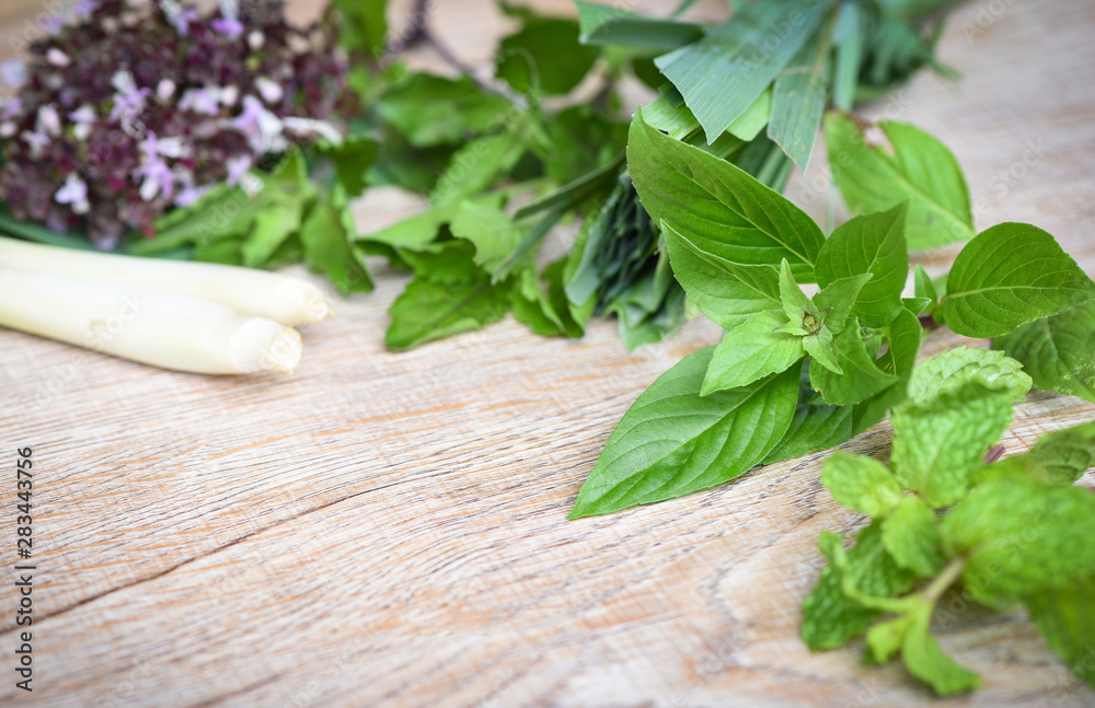 Fresh herbs and spices with sweet basil lemon grass holy basil peppermint leaf on wooden background - ingredient asian food Fresh herbs and spices with sweet basil lemon grass holy basil peppermint leaf on wooden background - ingredient asian food