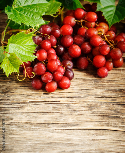 Fresh ripe red grapes on a wooden background.