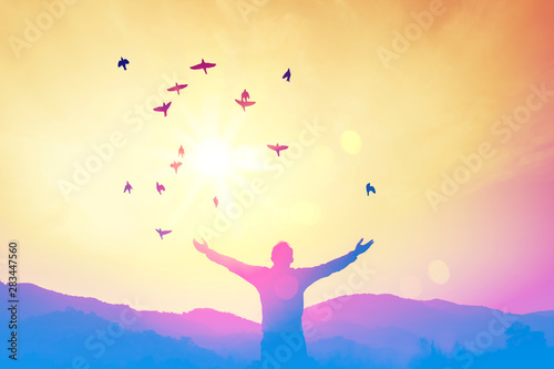 Copy space of man raise hand up on top of mountain and sunset sky abstract background.