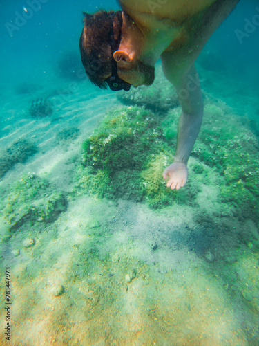 man swimming underwater with mask holding breath © phpetrunina14